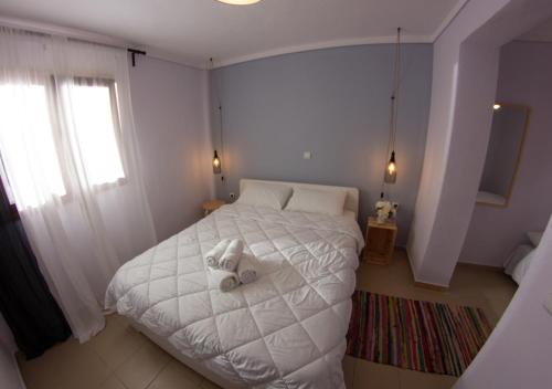 Un dormitorio con una cama blanca con un animal de peluche. en Beachfront stylish maisonette in Ierissos, en Ierissos