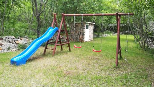 a playground with two swings and a slide at The Forest House Krk 1 in Kras
