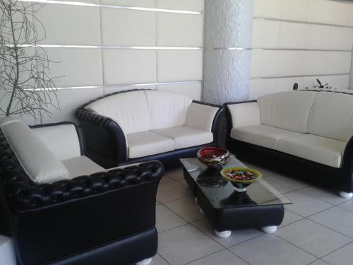 a living room with black and white chairs and a table at Green Hotel Ninfa in Avigliana