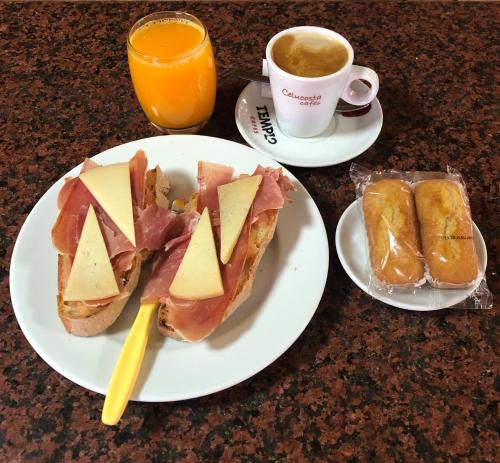 - une table avec deux assiettes de sandwichs et une tasse de café dans l'établissement Hostal Restaurante Taibilla, à Nerpio