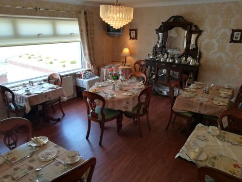 a dining room with tables and chairs and a mirror at Rosemount B&B in Dundalk