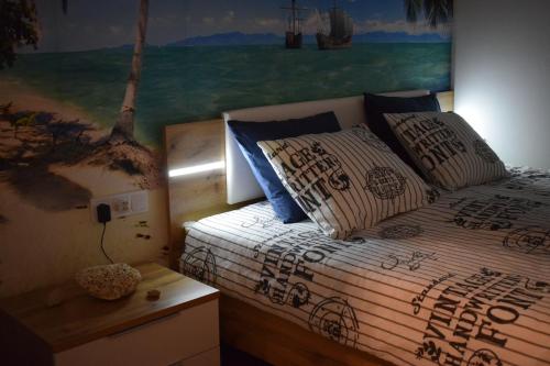 1 dormitorio con 1 cama con una pintura en la pared en Lido Riviéra, Relux Apartman Balatonlelle, en Balatonlelle