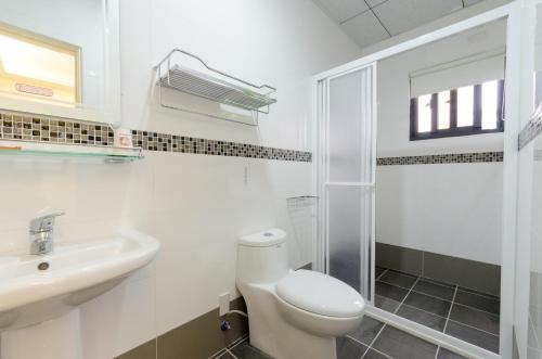 花蓮市にある9x9 Homestayのトイレと洗面台を備えた白いバスルーム
