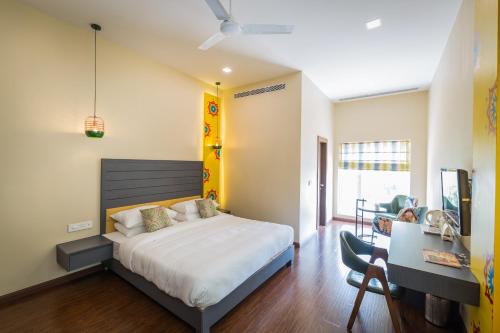 een slaapkamer met een bed en een bureau bij Hotel Asansol International in Āsansol