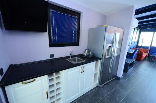a kitchen with a sink and a refrigerator at Batumi Palm Hotel in Batumi