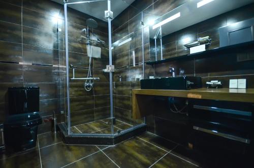 a large bathroom with a shower and a sink at Batumi Palm Hotel in Batumi