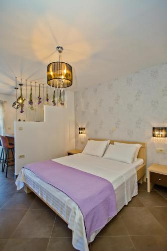 a bedroom with a large bed and a chandelier at Island Hvar Seaside Villa Levanda with Beach, Pool & Seaview in Hvar