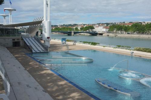 une grande piscine avec deux bateaux dans l'eau dans l'établissement Les Allées de Bellecour, à Lyon