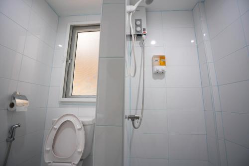 a white bathroom with a toilet and a shower at Dhub Hostel Donmueng in Bangkok
