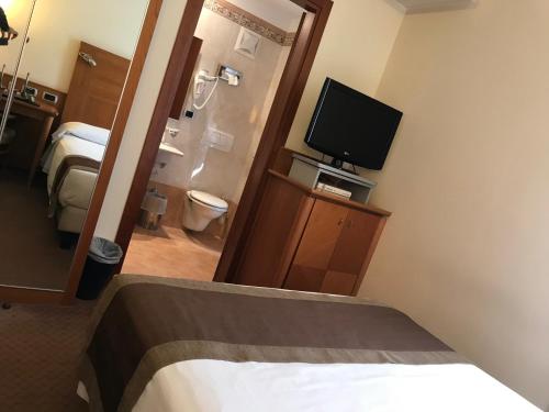 a hotel room with a bed and a flat screen tv at Hotel Master in Brescia