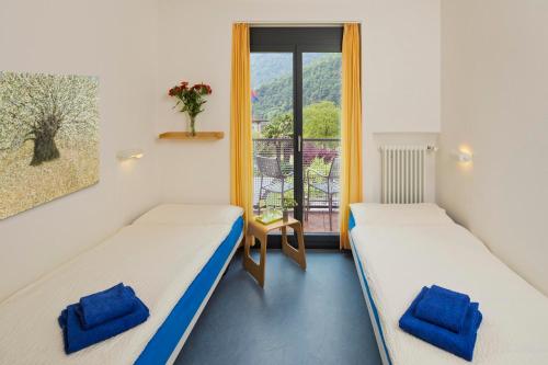 CoglioにあるEco-Hotel Cristallinaのバルコニー付きの客室内のベッド2台