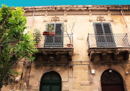 ein altes Gebäude mit zwei Fenstern und zwei Balkonen in der Unterkunft Le terrazze segrete in Palermo