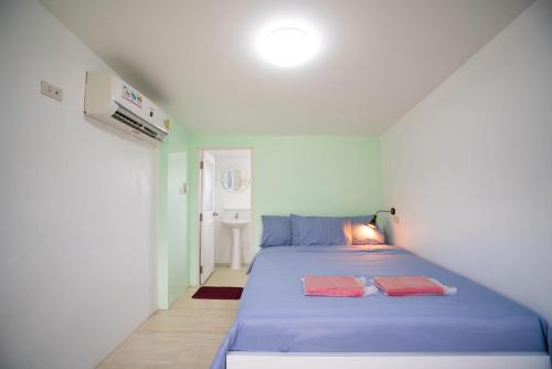a bedroom with a bed with two pillows on it at Dhub Hostel Donmueng in Bangkok