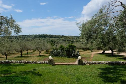 a garden with trees and a stone wall at Agriturismo Borgo degli ulivi in Canicattini Bagni