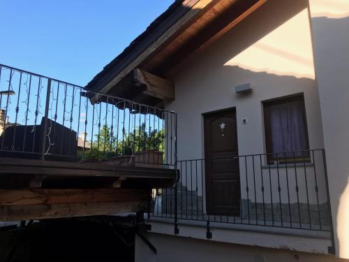 a balcony of a house with a door and a fence at B&B La Maison D' Amelie Camere e Appartamenti in Fenis