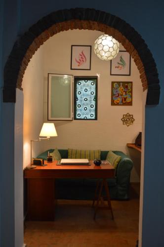 an archway with a desk and a couch in a room at RIAD OASIS D'ASILAH in Asilah