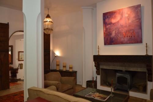 a living room with a fireplace and a painting on the wall at RIAD OASIS D'ASILAH in Asilah