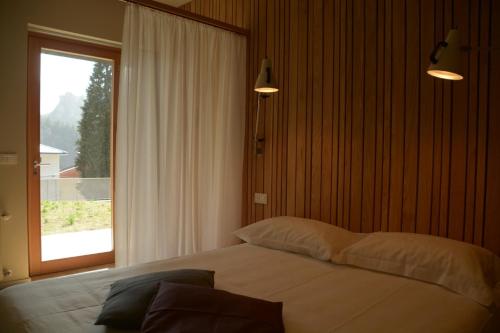 a bedroom with a large bed with a window at RELEVEN GUEST HOUSE in Vernante