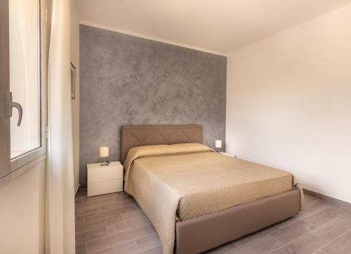 a bedroom with a bed and a wall at L'Antico Borgo B&B in Noto