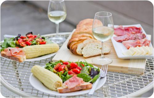 a table with two plates of food and glasses of wine at Memory House in Kutaisi