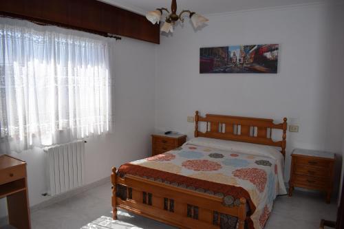 um quarto com uma cama, uma cómoda e janelas em El Molino em Melide