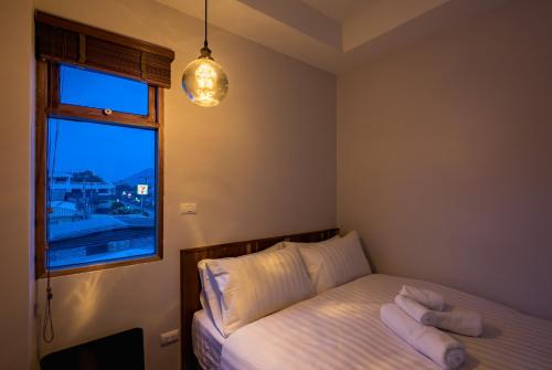 a bedroom with a bed with white pillows and a window at U Chiangkhan in Chiang Khan