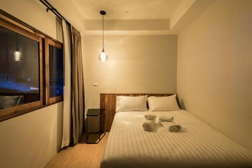 a bedroom with a bed with two towels on it at U Chiangkhan in Chiang Khan