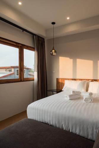 a bedroom with a large white bed with a window at U Chiangkhan in Chiang Khan