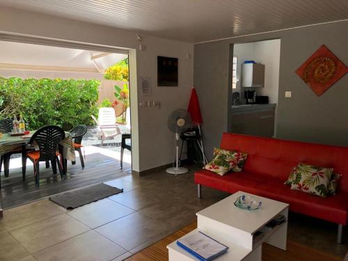 a living room with a red couch and a table at Cap Colibri in Petit-Bourg