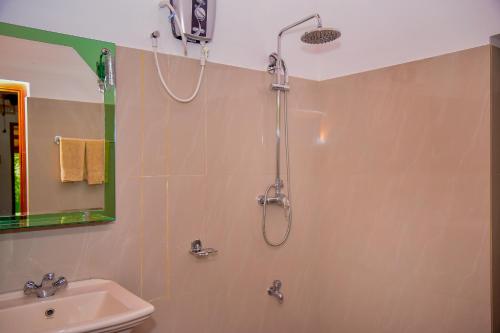 a bathroom with a shower and a sink at Richards Cabanas in Tissamaharama