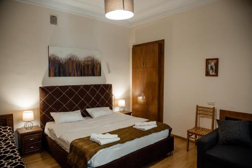 a bedroom with a large bed and a chair at Tbilisi Apartment 2 in Tbilisi City