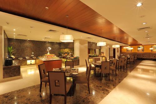 a restaurant with tables and chairs and a buffet at Mysore County Retreat in Mysore