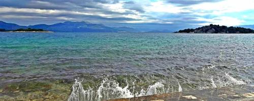 a large body of water with mountains in the background at Apartmani Urlic in Sreser