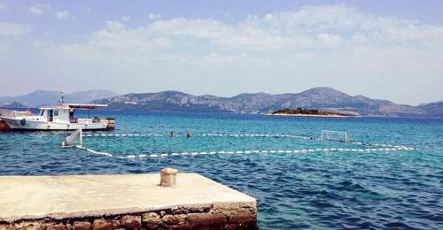 a boat is docked in the water with a goal at Apartmani Urlic in Sreser