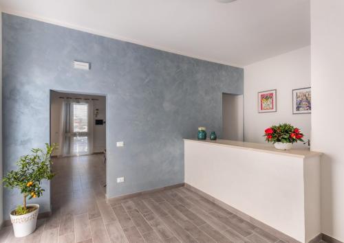 a living room with a gray wall with two potted plants at L'Antico Borgo B&B in Noto
