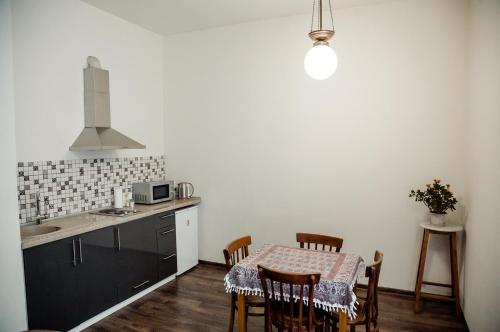 a kitchen with a table and chairs and a kitchen with white walls at Tbilisi Apartment in Tbilisi City