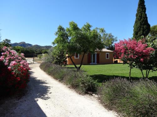 a dirt road leading to a house with trees and flowers at Mas'Xime in Saint-Rémy-de-Provence