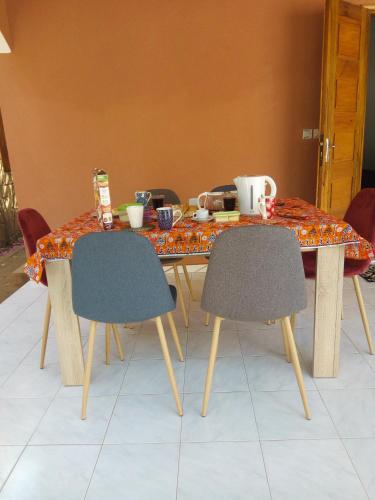 a dining table with two chairs and a table with at Chez Coumba et Daniel in Saly Portudal