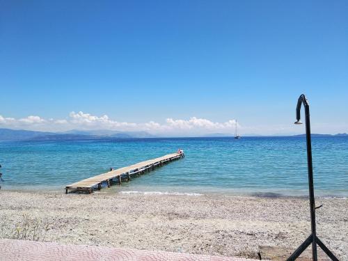a dock in the water on a beach at Luxurious bungalow in Ipsos beach in Ýpsos