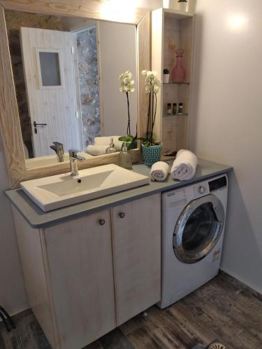 a bathroom with a sink and a washing machine at Luxurious bungalow in Ipsos beach in Ýpsos