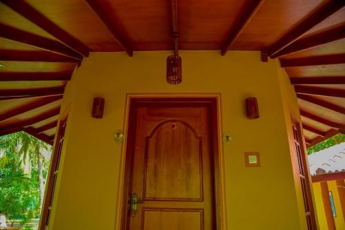 a yellow house with a door and a ceiling at Richards Cabanas in Tissamaharama