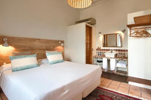 1 dormitorio con 1 cama blanca grande y lavamanos en Hotel Hanoi, en Begur
