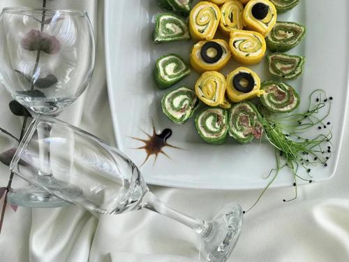 a plate of vegetables with a wine glass and a plate of food at Готель "Валерія" in Novoselytsya