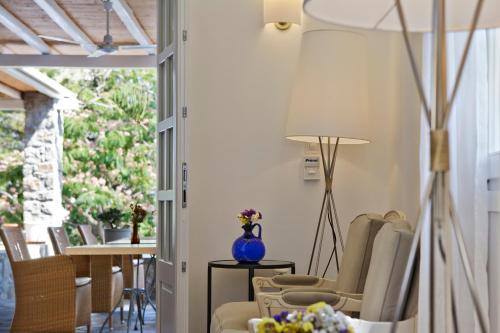 a living room with a table and chairs and a lamp at Kamari Hotel in Platis Yialos Mykonos