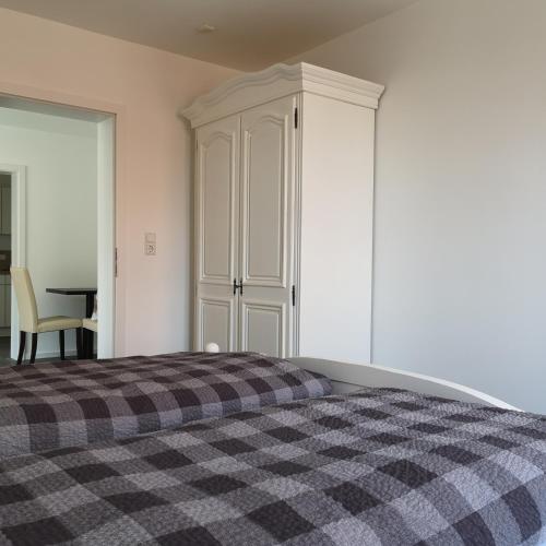 a bedroom with a bed and a cabinet and a table at Haus Worch in Juist