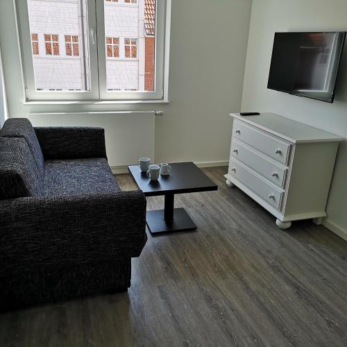 a living room with a couch and a tv and a table at Haus Worch in Juist