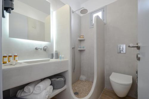 a white bathroom with a sink and a toilet at Prestige on the beach in Naxos Chora