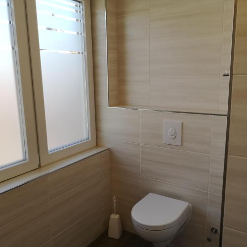 a bathroom with a toilet and a window at Haus Worch in Juist