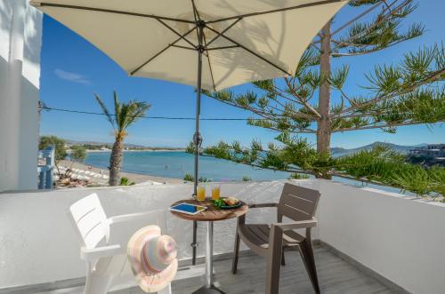 a table and chairs on a balcony with a view of the ocean at Prestige on the beach in Naxos Chora