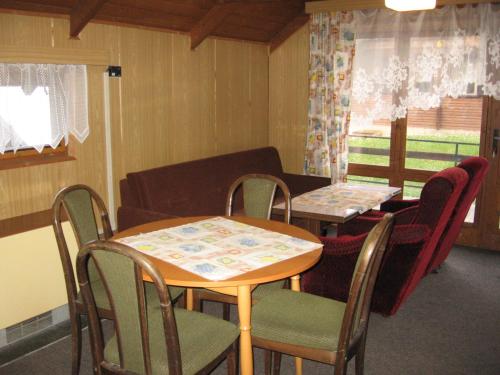 a room with two tables and chairs and a couch at Chaty u Loveckého zámečku in Buchlovice